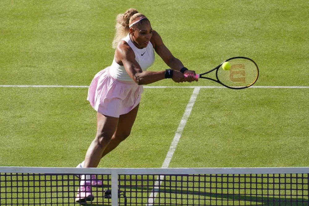 Serena Williams of the United States, hits a return as she and playing partner Victoria Mboko of Canada play against Nicole Melichar-Martinez of Canada and Erin Routliffe of New Zealand during their first round doubles match at the Queen's Club tennis championships in London, Tuesday, June 9, 2026. (AP Photo/Alberto Pezzali)