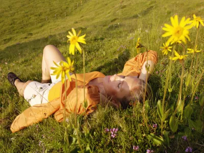 Austria, woman lying in meadow