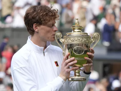 FILED - 13 July 2025, United Kingdom, London: Italian tennis player Jannik Sinner kisses the Gentlemen's Singles Trophy following his victory over Spain's Carlos Alcaraz in the Gentlemen's Singles Final on day fourteen of the 2025 Wimbledon Championships at the All England Lawn Tennis and Croquet Club. Photo: Andrew Matthews/PA Wire/dpa