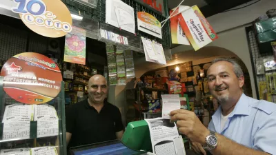 An unidentified man, right, shows his SuperEnalotto lottery ticket at a betting center in Castel Gandolfo, on the outskirts of Rome, Wednesday, Aug. 12, 2009. The record jackpot for Italy's state lottery increased to euro 131.5 million (6.2 million) after the latest drawing Tuesday again thwarted those hoping to get the winning, six-number combination. No one has hit the jackpot in the SuperEnalotto game since January, causing the prize to increase to the highest level in Italy's and Europe's history. The next drawing is Thursday. (AP Photo/Pier Paolo Cito)