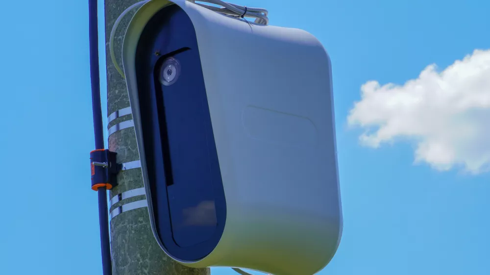 Closeup of a modern speed camera (traffic speed monitoring camera) against a clear blue sky