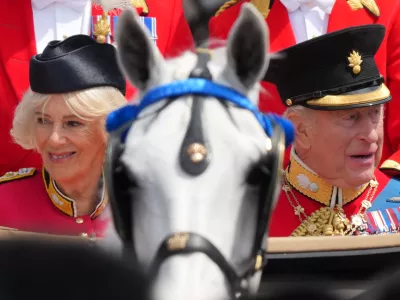 Britain's King Charles III, and Queen Camilla look out from their carriage at the crowds lining The Mall as they return to Buckingham Palace during Trooping The Colour, the King's annual birthday parade, in London, Saturday, June 13, 2026. (AP Photo/Kirsty Wigglesworth)