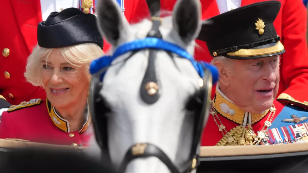 Britain's King Charles III, and Queen Camilla look out from their carriage at the crowds lining The Mall as they return to Buckingham Palace during Trooping The Colour, the King's annual birthday parade, in London, Saturday, June 13, 2026. (AP Photo/Kirsty Wigglesworth)