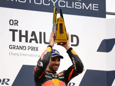 MotoGP - Thailand Grand Prix - Chang International Circuit, Buriram, Thailand - October 2, 2022 Red Bull KTM Factory Racing's Miguel Oliveira celebrates on the podium with the trophy after winning the race REUTERS/Athit Perawongmetha