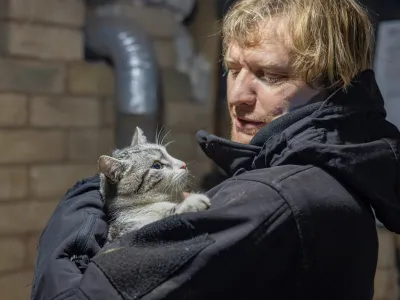 Ukrainian photographer Maksim Levin holds a cat near the line of separation from Russian-backed separatists in Luhansk region, Ukraine January 6, 2022. Picture taken January 6, 2022. REUTERS/Stanislav Kozliuk