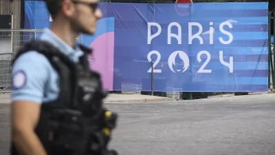 FILE - A police officer walks past a Paris Olympics canvas at the 2024 Summer Olympics, Saturday, July 20, 2024, in Paris, France. Three days before the start of the Olympics, France's Interior Minister has hailed the country's law enforcement for their hard work in making the Paris Games safe for 10,500 athletes and millions of visitors. (AP Photo/Thomas Padilla, File)