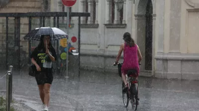 - 19.06.2019 &ndash; ljubljanski utrinek - kolesarka v dežju, nevihta - ploha -dež//FOTO: Luka Cjuha.