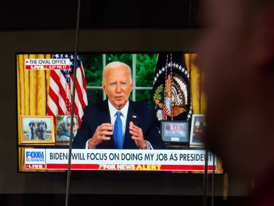 24 July 2024, US, New York: Passersby watching on a TV&nbsp;screen in Times Square US President Joe Biden addressing the nation about his decision to withdraw from the presidential race. Photo: Edna Leshowitz/ZUMA Press Wire/dpa