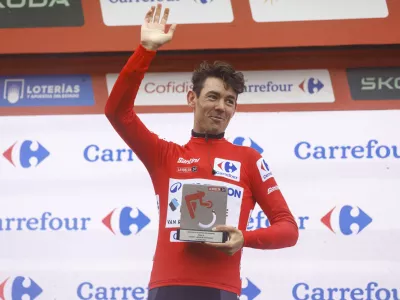 Avstralec Ben O'Connor je z zamudo pri&scaron;el na zmagovalni oder, a je nato z nasmehom poziral z rdečo majico vodilnega, ki jo je ubranil z zadnjimi atomi moči. Foto: Unipublic, A.S.O.