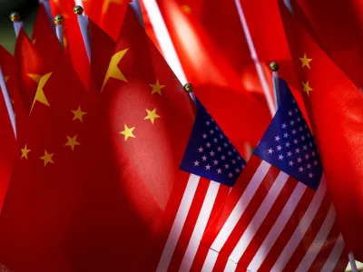 In this Sept. 16, 2018, photo, American flags are displayed together with Chinese flags on top of a trishaw in Beijing. The American Chamber of Commerce in China says Beijing will "dig its heels in" after U.S. tariff hikes and appealed for a negotiated end to their trade battle. The chamber on Tuesday, Sept. 18 warned a "downward spiral" appears certain after President Donald Trump approved a tariff hike on 0 billion of Chinese imports in a dispute over Beijing's technology policy. (AP Photo/Andy Wong)