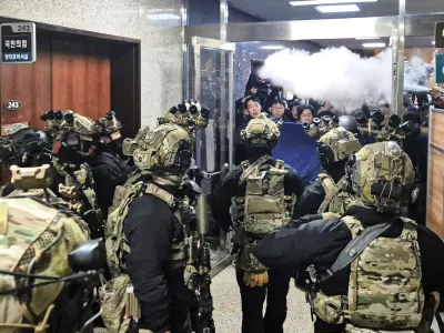 V južnokorejskem parlamentu so posku&scaron;ali preprečiti vstop varnostnim silam tudi z uporabo gasilnih aparatov. Foto: AP